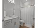 Bright bathroom with a white vanity, modern fixtures, and a shower with a white curtain at 17632 Santorini Ct, Venice, FL 34293