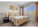 Inviting bedroom featuring a stylish bed with a decorative headboard and a light-filled window at 17632 Santorini Ct, Venice, FL 34293