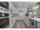 Gourmet kitchen featuring white cabinetry, stainless steel appliances, and a large sink with a backyard view at 17632 Santorini Ct, Venice, FL 34293