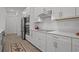 Modern kitchen with stainless steel appliances, white cabinets, and sleek countertops for a clean aesthetic at 17632 Santorini Ct, Venice, FL 34293