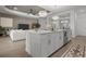 Open concept kitchen with an island that includes seating and stainless steel appliances overlooking the living room at 17632 Santorini Ct, Venice, FL 34293