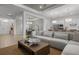 An expansive living space featuring a modern sectional and open access to the dining area and kitchen at 17632 Santorini Ct, Venice, FL 34293