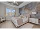 Luxurious primary bedroom featuring a king bed, large window and stylish decorative wall at 17632 Santorini Ct, Venice, FL 34293