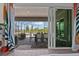 Indoor-outdoor living: open sliding glass doors to a covered patio with dining and lounging areas at 17632 Santorini Ct, Venice, FL 34293