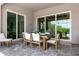 Covered patio featuring a wooden dining table with seating and tiled floor at 17632 Santorini Ct, Venice, FL 34293