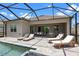 Spacious backyard with screened-in pool, patio dining and sun loungers for relaxation at 17632 Santorini Ct, Venice, FL 34293