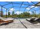 Relaxing screened-in pool area with inviting lounge chairs and serene water views at 17632 Santorini Ct, Venice, FL 34293
