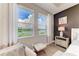 Bedroom with a view of the lake through bright windows and a cozy chair at 17898 Cherished Loop, Bradenton, FL 34211