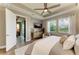 Comfortable bedroom featuring a ceiling fan and dresser with water view at 17898 Cherished Loop, Bradenton, FL 34211