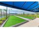Well-maintained bocce ball court with artificial turf, shaded seating, and lovely landscaping at 17898 Cherished Loop, Bradenton, FL 34211