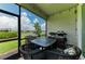 Screened lanai featuring a table, chairs, grill, and view of the lake at 17898 Cherished Loop, Bradenton, FL 34211