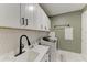 Bright laundry room with white cabinets, modern washer, countertop, and a stylish backsplash at 17898 Cherished Loop, Bradenton, FL 34211