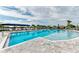 Sparkling community pool featuring comfortable lounge seating, shaded areas, and a tranquil lake view at 17898 Cherished Loop, Bradenton, FL 34211