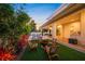 Beautifully landscaped backyard features a fire pit, lounge furniture, lush landscaping, and covered patio at 1954 Goldenrod St, Sarasota, FL 34239