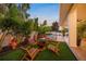 Relaxing backyard retreat features a fire pit, lounge furniture, lush landscaping, and covered patio at 1954 Goldenrod St, Sarasota, FL 34239