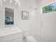 Modern bathroom features a glass-enclosed shower, white vanity, and a view of the outdoors at 1954 Goldenrod St, Sarasota, FL 34239