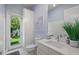 Bright bathroom featuring a door to the yard, white vanity, and blue wallpaper at 1954 Goldenrod St, Sarasota, FL 34239