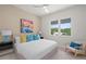 Bright bedroom featuring a comfortable bed, colorful artwork, and window view, promoting relaxation at 1954 Goldenrod St, Sarasota, FL 34239