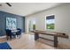 Bonus room features a shuffleboard table, round table with chairs, and a door to the balcony at 1954 Goldenrod St, Sarasota, FL 34239