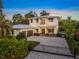 Stunning two-story home with a paved driveway, lush landscaping, and a metal roof at 1954 Goldenrod St, Sarasota, FL 34239