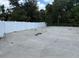 Long, narrow concrete backyard surrounded by a tall white privacy fence at 20170 Tralee Dr, Port Charlotte, FL 33952