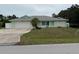 Exterior of home showcasing lush lawn, side privacy fence, and two-car garage in a sunny neighborhood at 20170 Tralee Dr, Port Charlotte, FL 33952