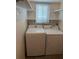 The laundry room has a full-size washer and dryer, plus shelving for convenient storage at 20170 Tralee Dr, Port Charlotte, FL 33952