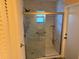 Walk-in shower featuring a frameless glass door, tile walls and flooring and grab bars at 20170 Tralee Dr, Port Charlotte, FL 33952