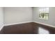 Empty room boasts wood flooring, neutral walls, and a window offering bright natural light at 208 Ariano Ave, Nokomis, FL 34275