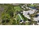 Aerial view of bocce ball courts with covered benches, adjacent to a parking area and lush trees at 208 Ariano Ave, Nokomis, FL 34275
