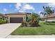 Charming single-story home with a well-manicured front yard and lush landscaping at 208 Ariano Ave, Nokomis, FL 34275