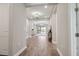 Hallway view that leads into the living area with wood floors and neutral paint throughout at 208 Ariano Ave, Nokomis, FL 34275