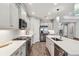Well-appointed kitchen features white cabinetry, quartz counters, tile backsplash, and stainless appliances at 208 Ariano Ave, Nokomis, FL 34275