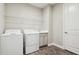 Laundry room with washer, dryer, sink, overhead shelving, and wood-look tile flooring at 208 Ariano Ave, Nokomis, FL 34275