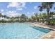 Resort-style pool surrounded by palm trees, lounge chairs, and shade umbrellas on a sunny day at 208 Ariano Ave, Nokomis, FL 34275