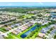 A scenic aerial view of a residential neighborhood, showcasing a serene pond and beautiful landscaping at 2085 Mattamy Ct, Venice, FL 34292