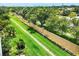 Aerial view of a meticulously landscaped yard, mature trees, and a well-maintained perimeter wall at 2085 Mattamy Ct, Venice, FL 34292