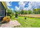 Beautiful backyard with lush landscaping, healthy green grass, and mature trees against a blue sky at 2085 Mattamy Ct, Venice, FL 34292