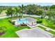 Aerial view of a community pool with a cabana, surrounded by lush landscaping and a white picket fence at 2085 Mattamy Ct, Venice, FL 34292