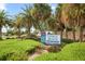 Welcoming Venice Beach sign surrounded by lush greenery and palm trees under a clear blue sky at 2085 Mattamy Ct, Venice, FL 34292