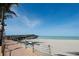 View of a sandy beach, paved walkway, and a wooden fishing pier extending into the ocean at 2085 Mattamy Ct, Venice, FL 34292
