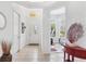 Bright, tiled foyer featuring a decorative table, an ornate mirror, and a view into the living area at 2085 Mattamy Ct, Venice, FL 34292