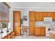 Well-lit kitchen features wooden cabinets, white appliances, breakfast nook, and a functional desk space at 2085 Mattamy Ct, Venice, FL 34292