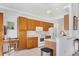 Bright kitchen featuring wooden cabinets, white appliances, a breakfast bar, and an adjacent desk area at 2085 Mattamy Ct, Venice, FL 34292