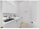 Clean laundry room featuring white cabinets, sink and modern washer and dryer at 2085 Mattamy Ct, Venice, FL 34292