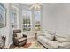 Cozy living room area with large windows, chair, and sofa for relaxing at 2085 Mattamy Ct, Venice, FL 34292