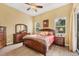 Comfortable main bedroom with wood floors, bedside tables, ensuite bath, and abundant natural light at 2085 Mattamy Ct, Venice, FL 34292