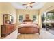 Main bedroom features tray ceiling, wood floors, generous natural light, and access to the screened lanai at 2085 Mattamy Ct, Venice, FL 34292