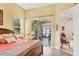 Sunny main bedroom with wood floors, tray ceiling, ensuite bath, and access to the screened lanai at 2085 Mattamy Ct, Venice, FL 34292