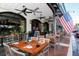 Outdoor seating area with tables and chairs under a covered awning, featuring an American flag and ceiling fans at 2085 Mattamy Ct, Venice, FL 34292